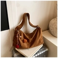 Detailed shot of a brown suede tote bag with side pleats and colorful fur pompom charms - Brown