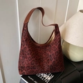 Vintage-Hobotasche mit Leopardenmuster und braunem Lederriemen in warmer Umgebung - Rot