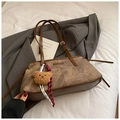 Nahaufnahme der braunen Vintage-Leder-Achseltasche mit Bärenanhänger und gewebten Seildetails - Mit Anhänger / Braun