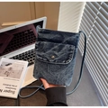 Detail showing washed denim fabric texture and metal button on the small crossbody phone bag - Style 1 / Vintage Blue