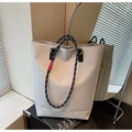 Détail d'un sac cabas à carreaux gris avec anses en corde et étiquette rouge - Blanc Cassé