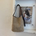 Dettaglio della borsa a secchiello in camoscio kaki con tracolla in corda intrecciata marrone - Cachi