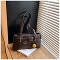 Close-up of chocolate brown leather bag with belt buckle and pom-pom charms - Coffee with Pendant