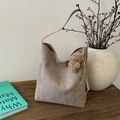 Detail der taupefarbenen Wildleder-Hobo-Tasche mit Teddy-Anhänger auf einem Holztisch - Camel (Mit Anhänger)