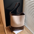 Sac seau bicolore marron et beige avec bandoulière fine posé sur une table en bois - Gris Beige