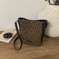 Détail du sac seau à motif léopard avec étiquette cuir NO FILTER sur bois - Imprimé léopard