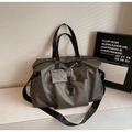 Detail of grey travel bag with buckle front pocket, sturdy handles and adjustable strap - Gray