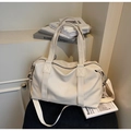 Close-up of cream Boston travel bag showing faux leather texture and reinforced handles - Off-white