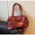 Detail of red PU leather travel bag with adjustable strap and silver metal zipper - Burgundy