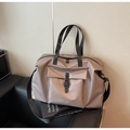 Close-up of high-density nylon travel tote featuring a buckle pocket and reinforced handles - Khaki