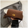 Detail of dark brown suede shoulder bag with vintage gold clasp and textured stitching - Brown