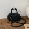 Detail of black textured leather handbag with vintage flower charm and silver hardware - With Charm / Black