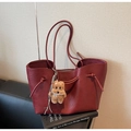 Dettaglio della borsa tote rosso scuro con nodi laterali e ciondolo orsetto di peluche - Rosso Vino (Con Ciondolo)
