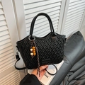 Black woven bucket bag with cylindrical handles and colorful beaded tassel accessory - Black