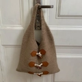 Sac fourre-tout en tricot camel avec fermoirs à bascule suspendu à une porte blanche - Kaki