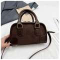 Vue détaillée de la texture du cuir suédé marron foncé et lisse sur un sac Boston - Café