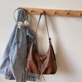 Bruine vintage leren hobo schoudertas met kwastje hangend aan een houten haakje - Bruin Zonder Hanger