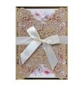 Detail of laser-cut invitation card with golden filigree and elegant satin ribbon bow - Beige Gold