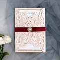 Detail view of laser-cut wedding invitation with pink pearlescent paper and red ribbon - Pink