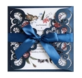 Detail van lasergesneden donkerblauwe trouwkaart met krulpatronen en een satijnen lint - Donkerblauw