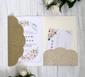 Close-up of laser-cut wedding invitation set with golden glitter pocket and floral design - Lapis Lazuli
