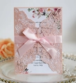 Detail of pink laser-cut wedding invitation with satin ribbon bow and floral insert - Light Pink