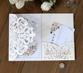 Elegant ivory laser cut floral invitation card set with RSVP on dark wood texture - Ivory