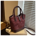 Détail du sac seau bordeaux avec texture en daim rétro et surpiqûres en cuir - Rouge