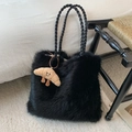 Detail of black faux fur tote bag featuring woven leather handles and a cute croissant charm - Black with Pendant