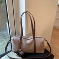 Detail of light brown matte suede boston bag featuring dark leather handles and fuzzy charm - With Pendant / Khaki