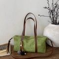Detalle de bolso Boston verde mate con correas de cuero marrón y borla trenzada - Verde con Colgante