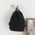 Minimalist black canvas backpack with large capacity and adjustable straps shown on wall - No Pendant / Black