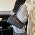 Bolso tote de cuero negro con cordones laterales mostrado en una modelo para estilo - Negro