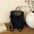 Dettaglio dello zaino nero in nylon con patta in pelle e ciondolo a forma di cane laterale - Nero con ciondolo