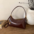 Dettaglio di borsa sottobraccio vintage in pelle marrone scuro con catena dorata - Marrone