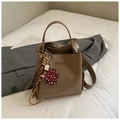 Detail of brown crocodile pattern bucket bag with bear charm and brand logo - Khaki