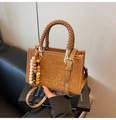 Detail of suede crossbody bag with embossed logo, braided handle and wooden bead charm - Khaki with Pendant