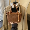 Sac seau à imprimé léopard marron avec finitions dorées et poignée porté par mannequin - Style Without Charm / Marron