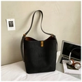 Detalle del bolso tote de ante negro con hebilla dorada junto a un ordenador portátil - Negro