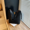 Minimalist black suede bucket bag with gold rotating lock and adjustable leather strap - Black