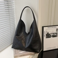 Grand sac hobo noir en similicuir texturé, porté épaule, dans un décor intérieur élégant - Noir