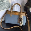 Sac seau patchwork en denim bleu et cuir marron avec fermoir rotatif en métal doré - Bleu