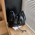 Chic black quilted drawstring bucket backpack with golden zippers and casual vintage style - Black
