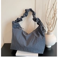 Detail der blau-grau karierten Segeltuchtasche mit gerafftem Cloud-Schultergurt auf Büchern - Blau