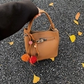 Brown lychee leather bucket bag with metal buckle and autumn tassel charm accessory - Brown with Pendant