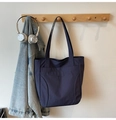 Detail of navy blue nylon tote bag with front pockets and brand embroidery logo - Blue
