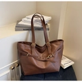 Detail view of a vintage brown leather tote bag showing adjustable straps and texture - Brown