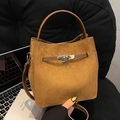 Vintage Eimertasche aus braunem Wildleder mit Tragegriff und elegantem Metalldrehverschluss - Wildleder Textur Stil / Mattbraun