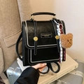 Chic black leather backpack with silver studs and a plush bear charm for travel - With Charm / Black