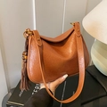 Halbmond-Schultertasche in Karamellbraun mit Quaste und Holzperle aus Leder mit Narbung - Braun mit Anhänger